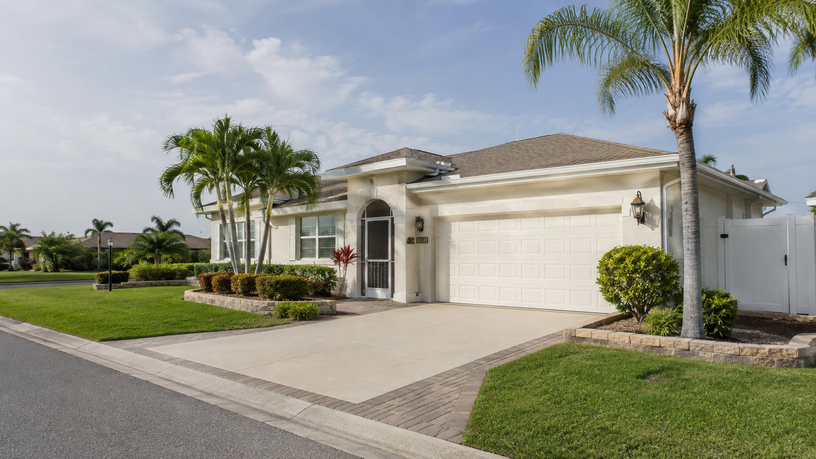 Clean Cape Coral home with washed exterior, driveway, walkway, and vinyl fence